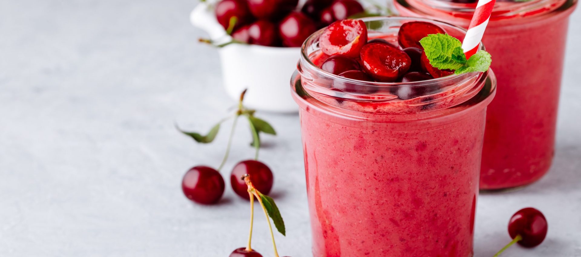 Cherry smoothie in glass with mint leaves and fresh berries